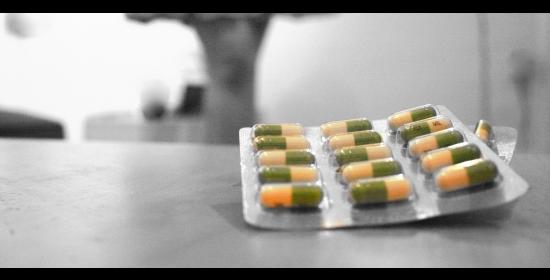packet of prozac pills sitting on a counter with a figure in the background
