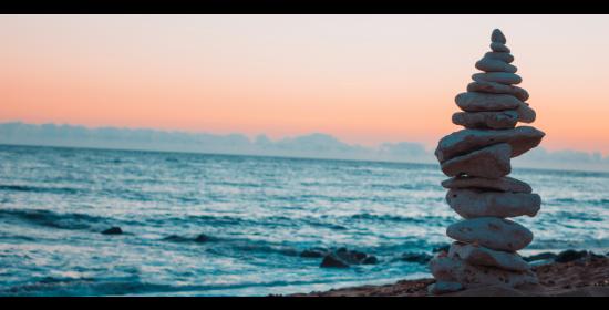 stack of rocks by the ocean at sunset