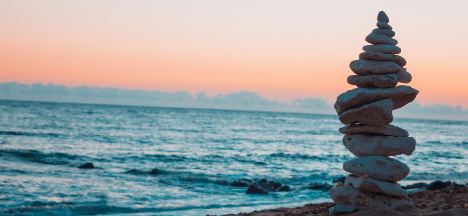 stack of rocks by the ocean at sunset