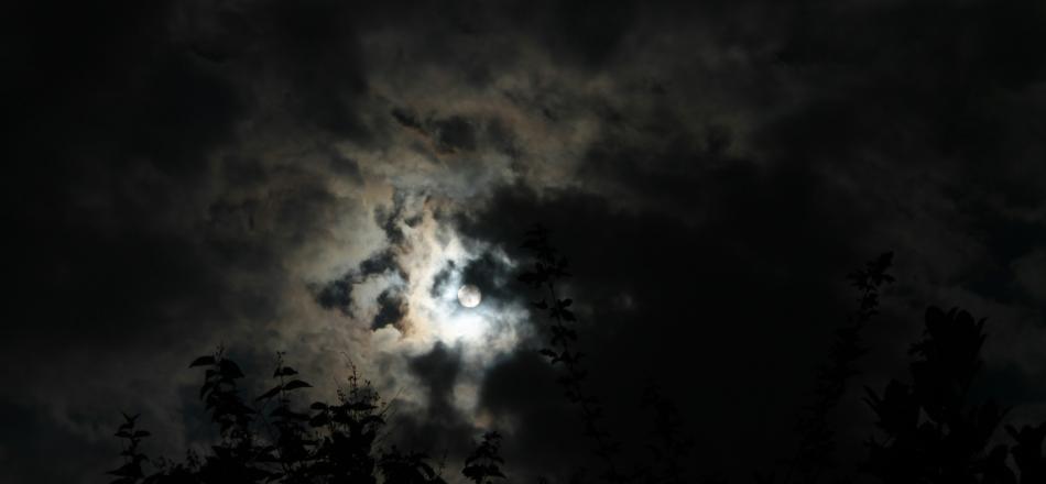 A photograph of the moon in a cloudy night sky
