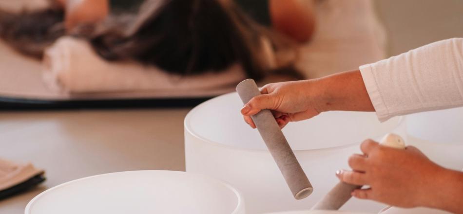 photo of practitioner playing sound bowls