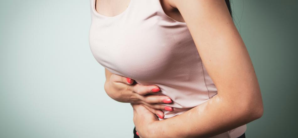 woman with IBS holding her stomach in pain