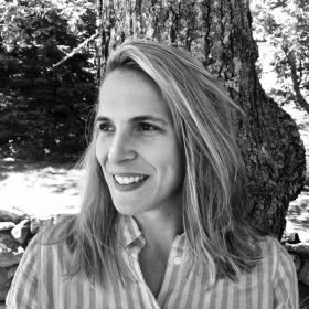 black and white photo of a woman smiling in a striped shirt