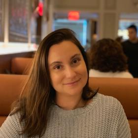 woman with brown hair smiling in a restaurant