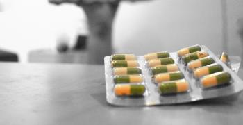 packet of prozac pills sitting on a counter with a figure in the background