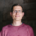 man smiling wearing glasses and a t-shirt