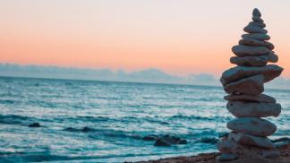 stack of rocks by the ocean at sunset
