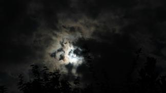 A photograph of the moon in a cloudy night sky 