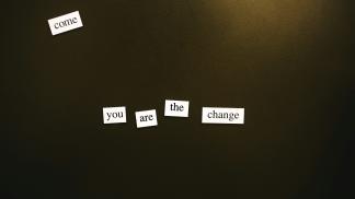 White single-word tiles on a dark background spelling out 'you are the change'.