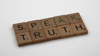 Scrabble tiles that spell out "speak truth"
