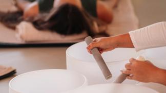 photo of practitioner playing sound bowls