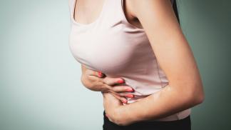 woman with IBS holding her stomach in pain